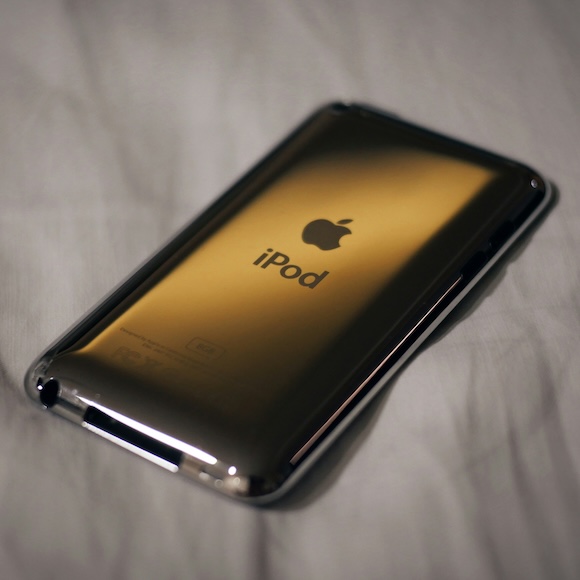 The view of the back of a silver iPod on a cream-colored tablecloth
