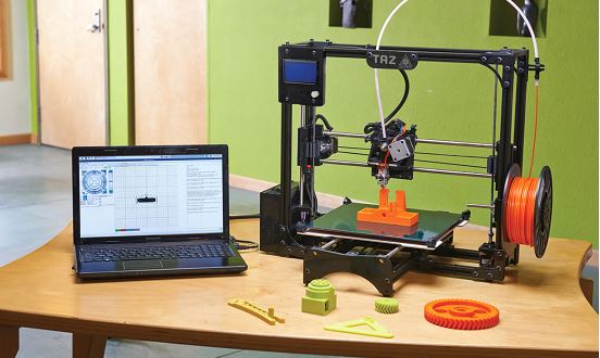 Laptop and a 3D printer on a wooden table