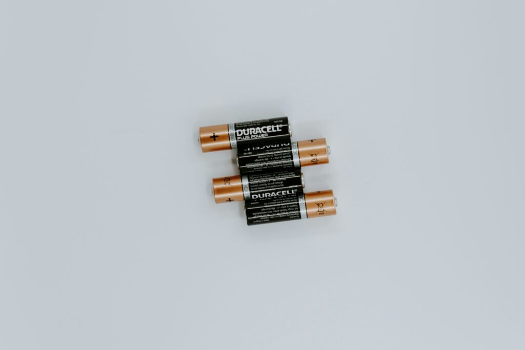 Four Duracell AA batteries on a white table