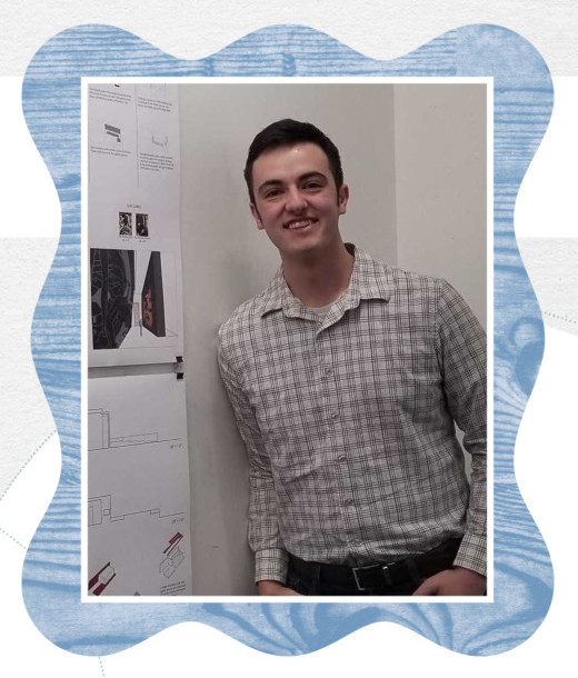 Who is this Geek in their 20s? It's Graden smiling at the camera, and he's standing in a classroom next to his architecture poster project.
