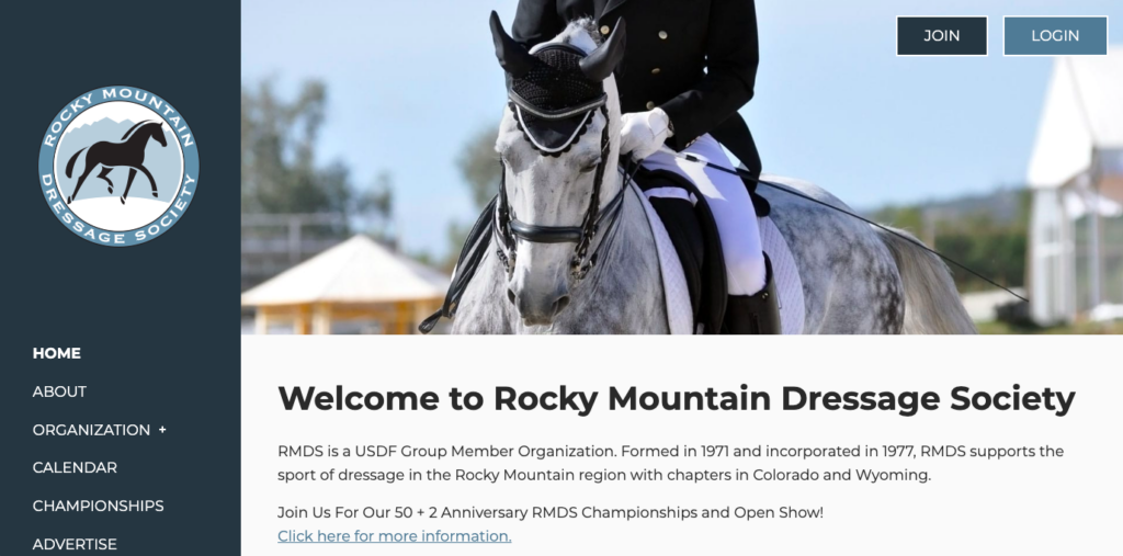 Homepage for the Rocky Mountain Dressage Society website, featuring a rider in a black coat and white riding pants sitting on top of a white and gray horse