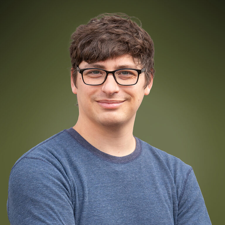 Developer Spencer Flores in a blue shirt with glasses.