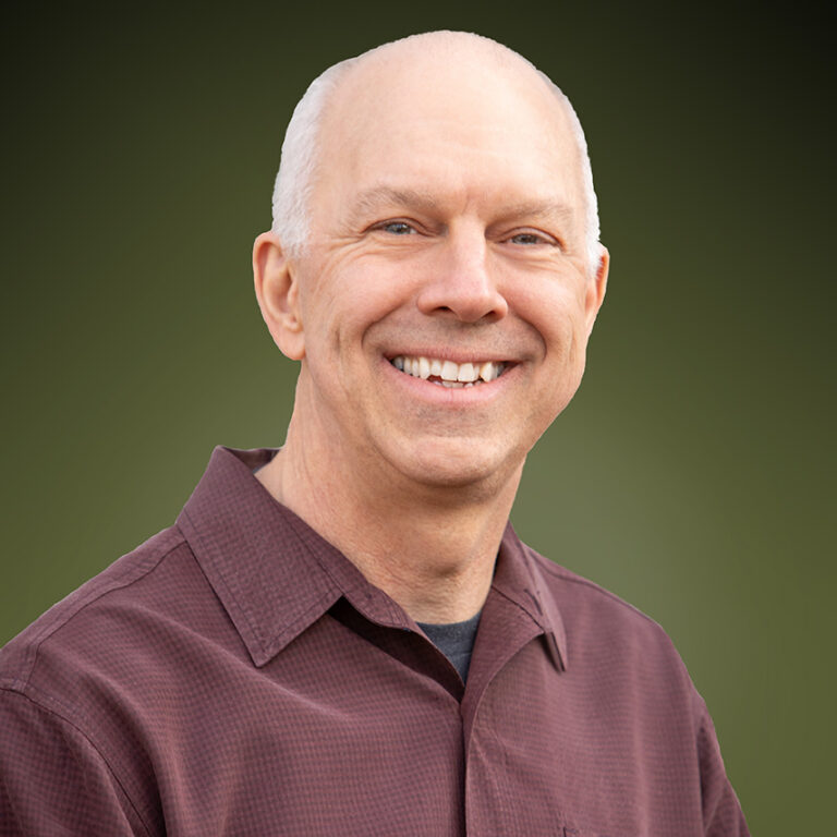 Ron Zasadzinski smiling in a redshirt.